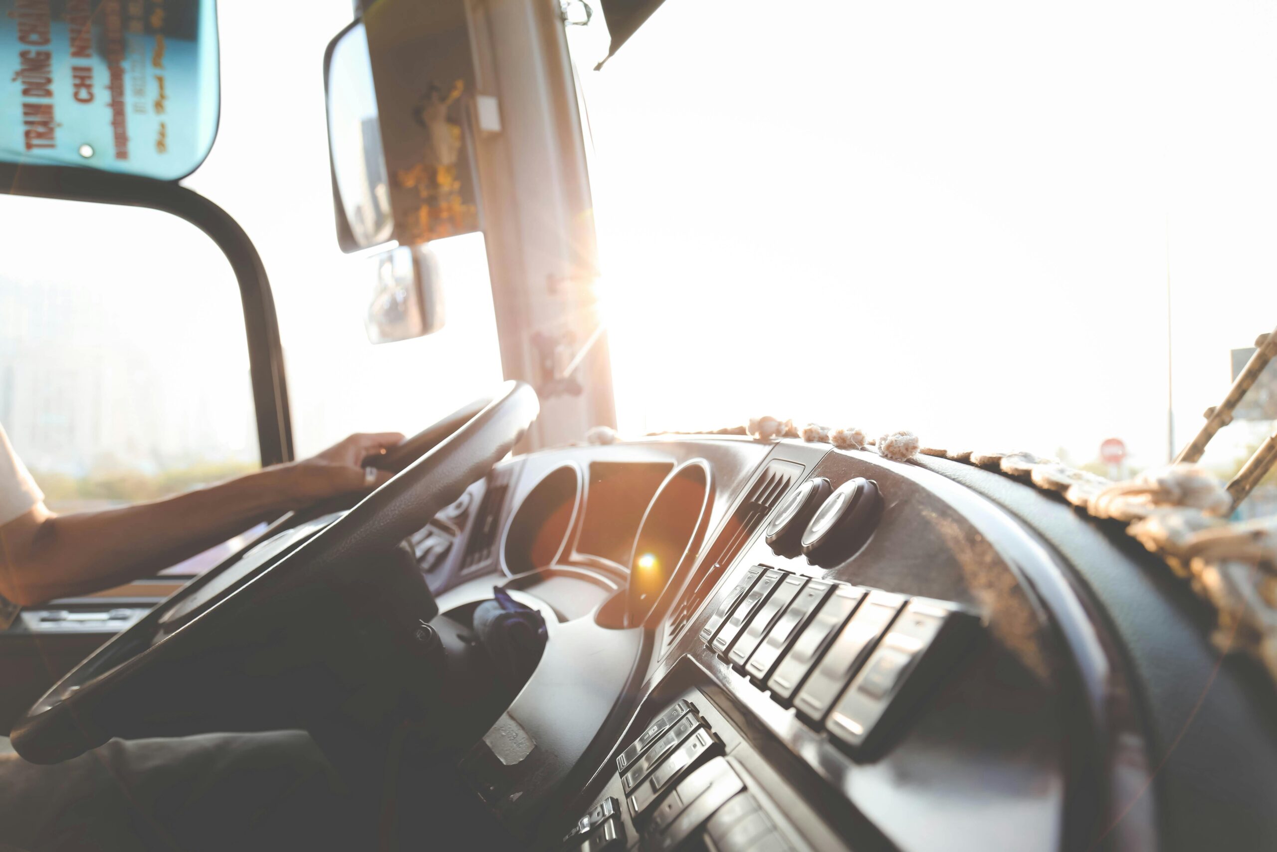 pexels-photo-977213-977213 A bus driver navigating the city streets during a sunny day, focusing on the road.